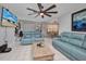 Comfortable living room featuring a ceiling fan, tile floors, recliners, and a mounted television at 2465 Deedra St, Port Charlotte, FL 33952