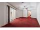 Spacious bedroom featuring a ceiling fan, red carpet, and sliding glass door leading to lanai at 25538 Rampart Blvd, Punta Gorda, FL 33983