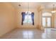 Bright living room with tile flooring, large window, and elegant chandelier, perfect for relaxing or entertaining guests at 25538 Rampart Blvd, Punta Gorda, FL 33983