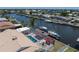 Aerial view of a screened-in pool, patio, and boat dock along the canal at 259 Fields Ter, Port Charlotte, FL 33952