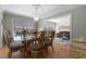 Elegant dining room with a glass-top table, ornate chairs, chandelier, and view through to the open living area at 259 Fields Ter, Port Charlotte, FL 33952