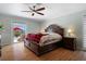 Bedroom with hardwood floors, ceiling fan and a window overlooking the backyard patio and pool at 259 Fields Ter, Port Charlotte, FL 33952