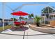 Outdoor patio area features a dining set, a red umbrella, and beautiful water views at 259 Fields Ter, Port Charlotte, FL 33952