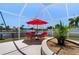 Waterfront patio area features an outdoor dining set with a red umbrella, perfect for entertaining at 259 Fields Ter, Port Charlotte, FL 33952