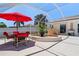 Outdoor patio area features a dining set, a red umbrella, and a relaxing hot tub at 259 Fields Ter, Port Charlotte, FL 33952