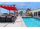 Outdoor space featuring a pool, covered patio with comfortable seating, and lush landscaping for entertaining at 259 Fields Ter, Port Charlotte, FL 33952