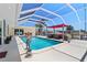 Screened-in lanai featuring a sparkling pool, covered seating area, and access to waterfront with boat dock at 259 Fields Ter, Port Charlotte, FL 33952