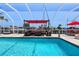 Waterfront pool featuring a relaxing lounge area with a red awning and scenic water views at 259 Fields Ter, Port Charlotte, FL 33952