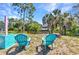 Serene backyard setting featuring comfortable seating, waterfront views, and lush tropical foliage at 2626 Auburn Blvd, Port Charlotte, FL 33948