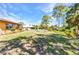 Expansive backyard features a lush lawn with mature trees and waterfront views at 2626 Auburn Blvd, Port Charlotte, FL 33948