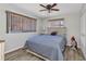 Bedroom with wood-look flooring, ceiling fan, natural light from two windows, and a closet with bi-fold doors at 2626 Auburn Blvd, Port Charlotte, FL 33948