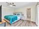 Comfortable bedroom features wood-look flooring, a ceiling fan, and an attached bathroom for added convenience at 2626 Auburn Blvd, Port Charlotte, FL 33948