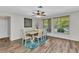 The dining room has a light wood table, four chairs, and is bright with natural sunlight at 2626 Auburn Blvd, Port Charlotte, FL 33948