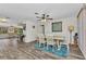Bright dining area with wood-look floors, stylish ceiling fan, and a blue rug defining the space at 2626 Auburn Blvd, Port Charlotte, FL 33948