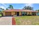 Charming single-story home with brick driveway, well-maintained lawn, and mature trees on a sunny day at 2626 Auburn Blvd, Port Charlotte, FL 33948