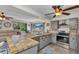 Open-concept kitchen with tile countertops, grey cabinetry, and seamless flow into the cozy living room at 2626 Auburn Blvd, Port Charlotte, FL 33948