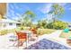 Back patio with outdoor seating offers a scenic view of the landscaped yard and mature trees at 2626 Auburn Blvd, Port Charlotte, FL 33948