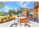 Outdoor patio with dining set, perfect for enjoying the serene backyard views and waterfront scenery at 2626 Auburn Blvd, Port Charlotte, FL 33948