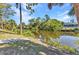 Enjoy this home's waterfront views from your backyard surrounded by a canal and beautiful lush trees and tropical plants at 2626 Auburn Blvd, Port Charlotte, FL 33948