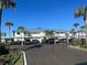 Exterior of the condo with covered parking, blue skies, and palm trees at 26430 Rampart Blvd # 511, Punta Gorda, FL 33983