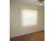 Bedroom with wood floors and bright window with blinds at 26430 Rampart Blvd # 511, Punta Gorda, FL 33983