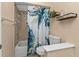 Cozy bathroom featuring a shower-tub combo, a floral-themed shower curtain, and tiled walls at 3225 Magnolia Way, Punta Gorda, FL 33950