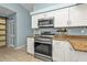 Modern kitchen features white cabinetry, granite countertops, and stainless steel appliances for a sleek and functional space at 3225 Magnolia Way, Punta Gorda, FL 33950