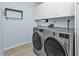 Efficient laundry room with stainless steel washer and dryer, and upper cabinets at 3225 Magnolia Way, Punta Gorda, FL 33950