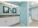 Bright, light-blue ensuite bathroom featuring a double vanity with granite counters and white cabinets at 3225 Magnolia Way, Punta Gorda, FL 33950