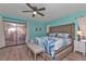 Light-blue main bedroom with a decorative ceiling fan and sliding glass doors to the outdoor lanai at 3225 Magnolia Way, Punta Gorda, FL 33950