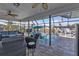 Screened-in patio featuring wicker furniture overlooking a pool and canal at 3225 Magnolia Way, Punta Gorda, FL 33950