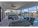 Screened-in patio with wicker furniture overlooking a pool and canal at 3225 Magnolia Way, Punta Gorda, FL 33950