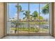 Balcony view with a screen, overlooking a canal, palm trees, and clear blue sky at 3314 Wood Thrush Dr # 124, Punta Gorda, FL 33950