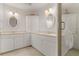 Elegant bathroom featuring white vanities with marble countertops, framed mirrors, and a glass-enclosed shower at 3314 Wood Thrush Dr # 124, Punta Gorda, FL 33950