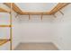 Bright walk-in closet featuring wooden shelving, providing ample storage space for clothes and accessories at 3314 Wood Thrush Dr # 124, Punta Gorda, FL 33950