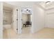 Hallway view featuring a bathroom with a shower and a bedroom with a blue chair and ceiling fan at 3314 Wood Thrush Dr # 124, Punta Gorda, FL 33950