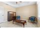 Neutral-toned living room featuring tile flooring, a ceiling fan, and wooden display cabinet and blue chairs at 3314 Wood Thrush Dr # 124, Punta Gorda, FL 33950