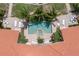 Aerial view of resort-style pool surrounded by lush landscaping, lounge chairs, and brick pavers at 3314 Wood Thrush Dr # 124, Punta Gorda, FL 33950