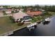Aerial view of a waterfront home with a screened-in pool and a private boat dock on a tranquil canal at 3518 Terin Ct, Punta Gorda, FL 33950