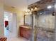 Bathroom featuring a stylish vanity, tiled shower with glass surround, and access to the commode room at 3518 Terin Ct, Punta Gorda, FL 33950