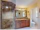Bathroom with stylish vanity, framed mirror, and tiled shower with frameless glass surround at 3518 Terin Ct, Punta Gorda, FL 33950