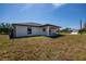 A view of the back of the home that features a covered porch and sliding glass door at 359 Salisbury St, Port Charlotte, FL 33954