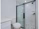 A bathroom featuring a modern shower with glass door, pebbled floor and white marble tiles at 359 Salisbury St, Port Charlotte, FL 33954
