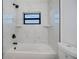 Modern bathroom featuring white marble-style tiling and dark fixtures at 359 Salisbury St, Port Charlotte, FL 33954
