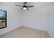 Bright bedroom features light wood floors, a ceiling fan, and a large window at 359 Salisbury St, Port Charlotte, FL 33954