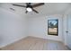 This bedroom has light wood floors, a ceiling fan, and natural light from a large window at 359 Salisbury St, Port Charlotte, FL 33954