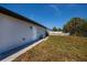 Side view of the house showing the exterior wall, a service door, and the surrounding yard at 359 Salisbury St, Port Charlotte, FL 33954
