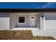 Charming home entrance featuring a white front door, small window, and attached garage at 359 Salisbury St, Port Charlotte, FL 33954
