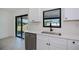 Contemporary kitchen showcasing white cabinetry, a stainless steel dishwasher, and an undermount sink with modern fixtures at 359 Salisbury St, Port Charlotte, FL 33954