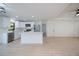 Modern kitchen with white cabinets, stainless steel appliances, an island, and wood flooring that opens to the living area at 359 Salisbury St, Port Charlotte, FL 33954